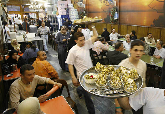 Waiters at Bikdash shop in Old Damascus carry plates of hand made ice-cream, Syria.