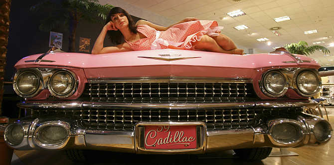 A model poses on the hood of a 1961 Cadillac at the Dream Car exhibition in Budapest, Hungary.