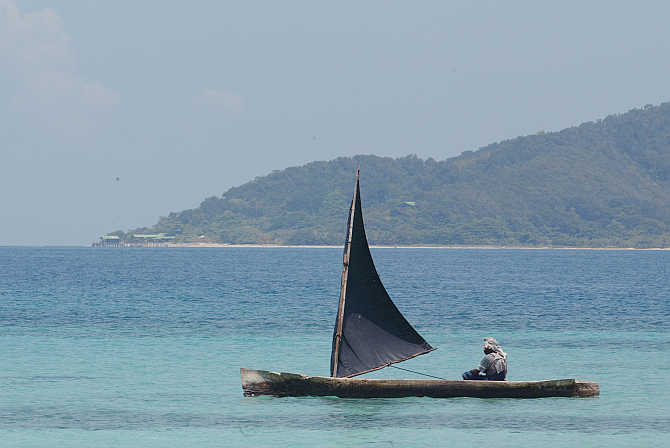 A man steers his canoe offshore of Cayo Cachahuate on the northern coast of Honduras.