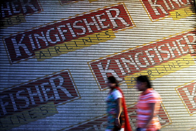 Women walk past a closed booking office of Kingfisher Airlines in New Delhi October 1, 2012.