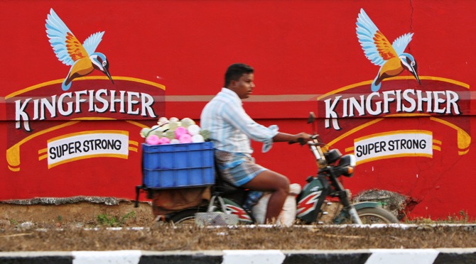 A man on a motorbike rides past the factory of United Breweries Ltd (UB) that manufactures Kingfisher beer in Thiruvalluar district of Tamil Nadu.