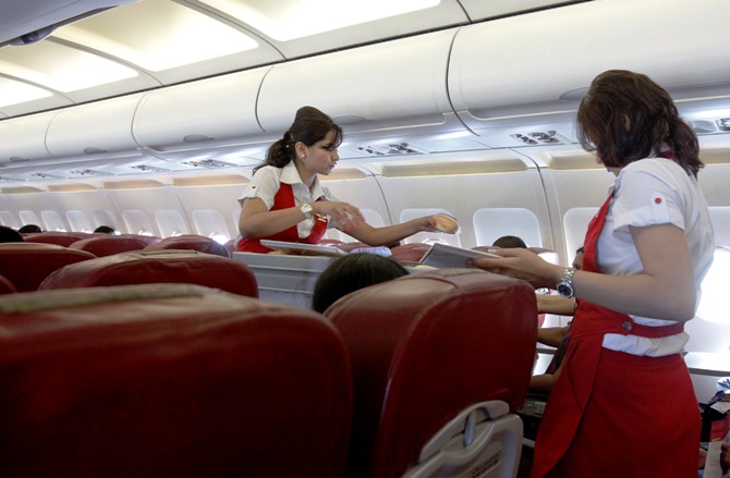 Kingfisher Airlines cabin attendants serve snacks on a flight after takeoff from Mumbai's domestic airport March 20, 2012.