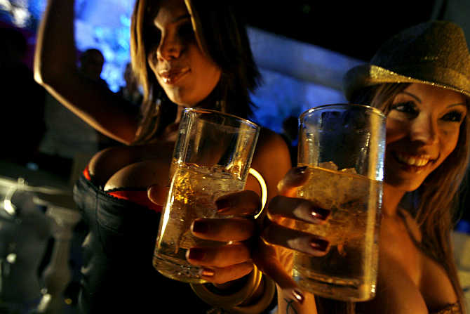 Women dance and drink whisky during a Playboy magazine party in Caracas, Venezuela.