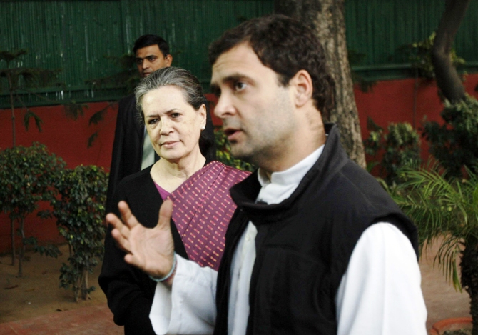 Congress chief Sonia Gandhi (left) watches as her son Rahul Gandhi speaks during a press conference in New Delhi December 8, 2013.