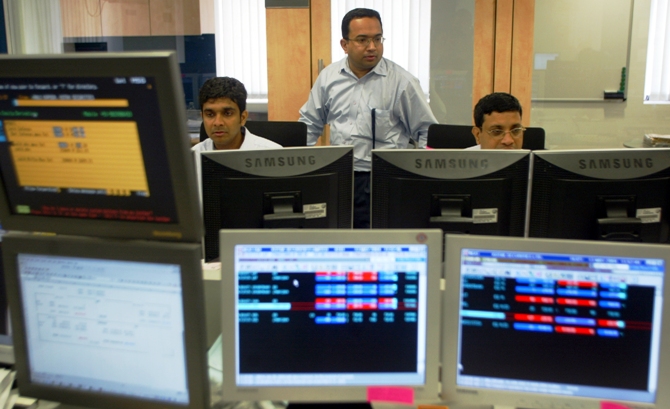 Stock brokers keep watch on the key Sensex share index graph in a brokerage firm in Mumbai.