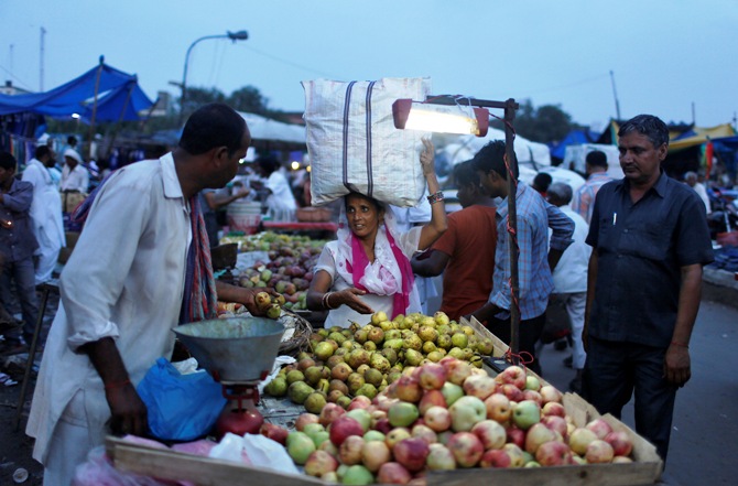 A customer buys fruits from a roadside market in the old quarters of Delhi.