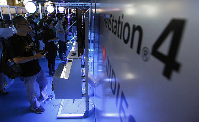 Visitors try out PlayStation 4 game console at the Tokyo Game Show in Chiba, east of Tokyo, Japan.