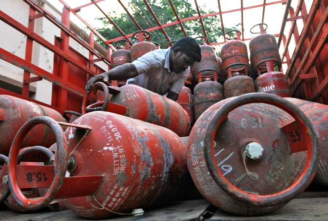A worker loads empty Liquefied Petroleum Gas cylinders onto a supply truck in Chennai.