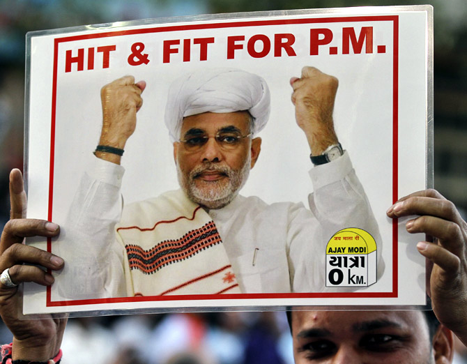 A supporter of the Bharatiya Janata Party (BJP) holds a poster featuring Narendra Modi.