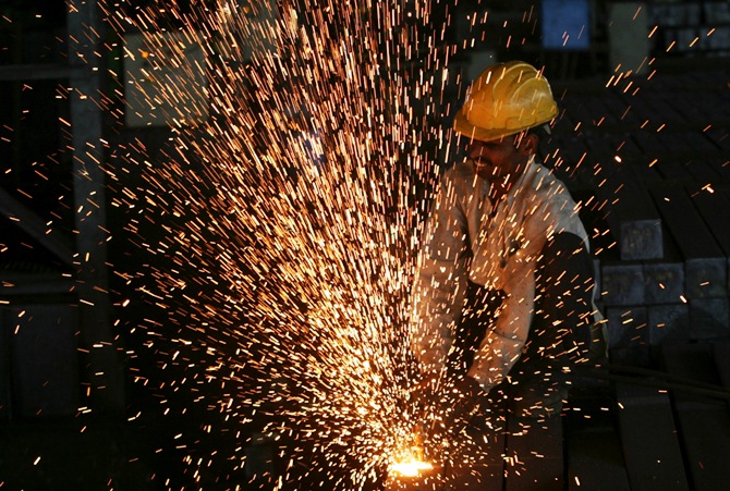 A worker cuts steel bars inside a factory on the outskirts of the southern Indian city of Hyderabad.