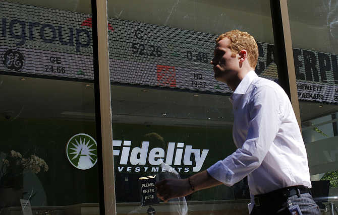 A pedestrian walks past a stock ticker at a Fidelity Investments office in Boston, Massachusetts.