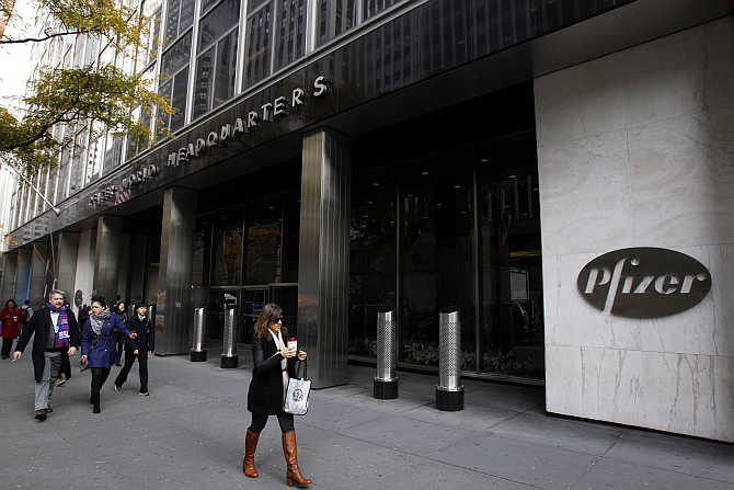 Pedestrians walk past the world headquarters of Pfizer in New York.