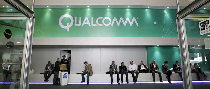 People sit next to a Qualcomm stand at the Mobile World Congress in Barcelona, Spain.