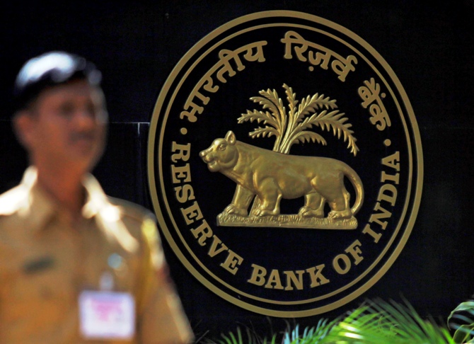 A policeman walks past the logo of the Reserve Bank of India outside its head office in Mumbai.