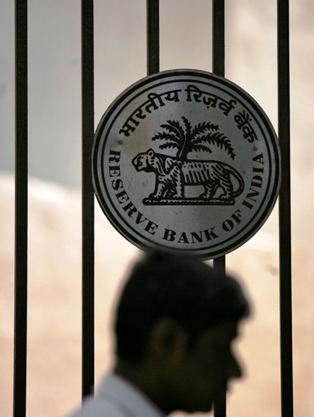 A man walks past the logo of the Reserve Bank of India outside its head office in Mumbai.