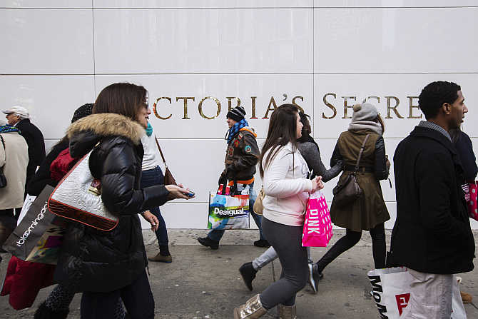 Pedestrians carrying shopping bags walk past a Victoria's Secret store in New York.