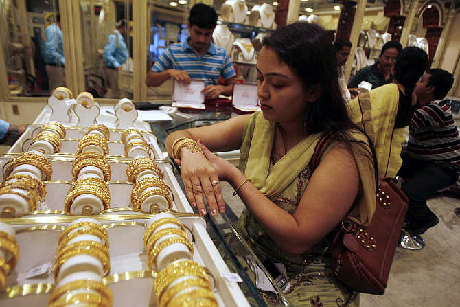 A woman tries on a gold bracelet at a jewellery showroom in Siliguri.