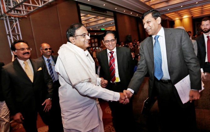 RBI Governor Rajan (2nd R) shakes hands with India's Finance Minister Palaniappan Chidambaram (3rd L) as they arrive to attend the Delhi Economics Conclave 2013 in New Delhi December 11, 2013.
