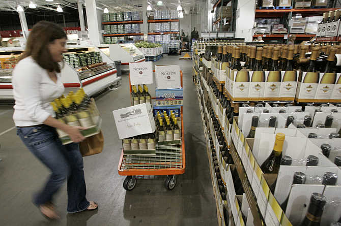 A shopper loads cartons of wine onto her cart at the Costco Warehouse in Arlington, Virginia.