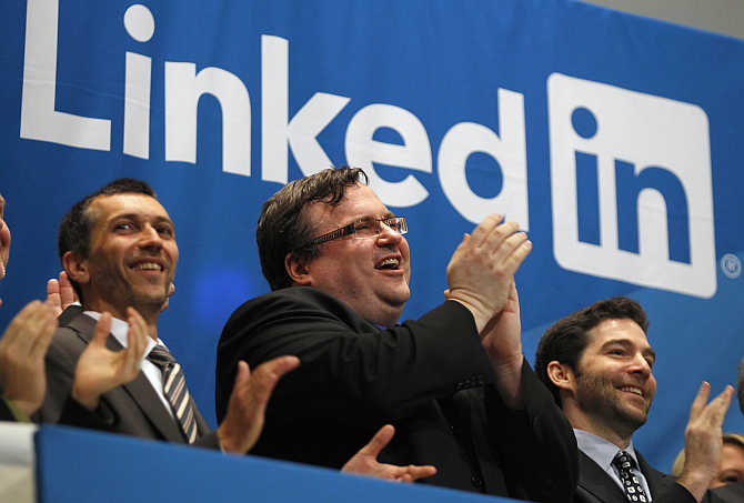 Founder of Linkedin Reid Garrett Hoffman, centre, applauds with CEO Jeffrey Weiner, right, from the bell balcony at the New York Stock Exchange.