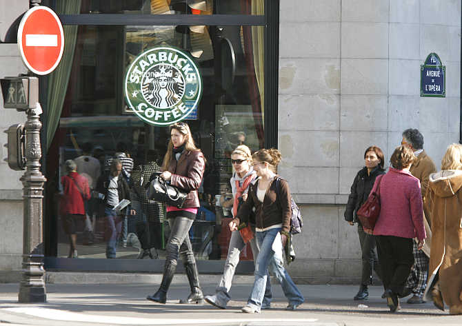 Pedestrians pass by Starbucks's coffee house in Paris.