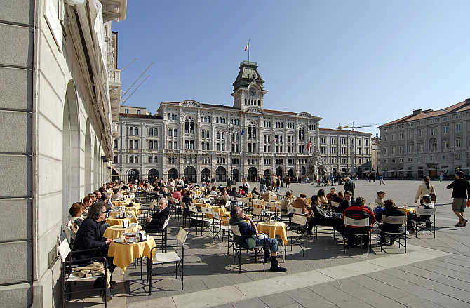 People gather at an outdoor cafe in the main square in Trieste, Italy.
