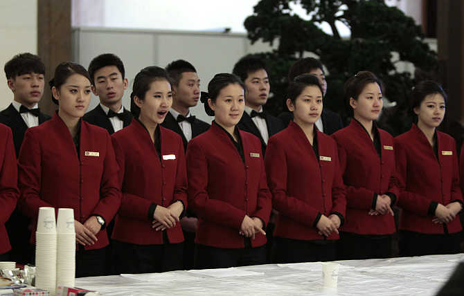 Tea attendants wait to serve delegates during the plenary meeting of the National People's Congress, China's parliament, at the Great Hall of the People in Beijing.