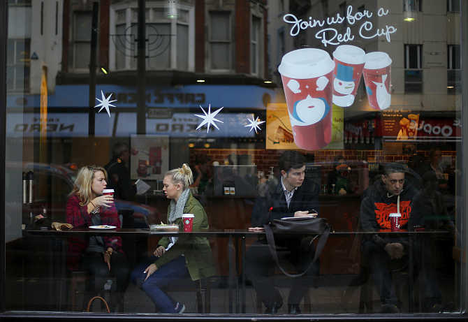 Patrons sit in a Starbucks Coffee shop in central London.
