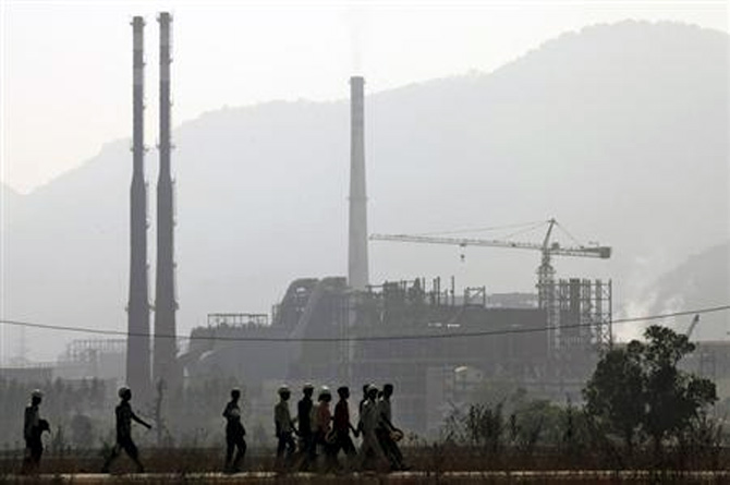 Workers walk in front of the Vedanta Aluminium factory in Lanjigarh in Orissa.