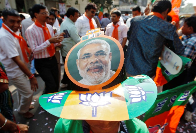 A supporter wearing a cap carrying a picture of Gujarat's Chief Minister Narendra Modi, prime ministerial candidate for Bharatiya Janata Party, attends the celebrations outside the party's headquarters in Ahmedabad.