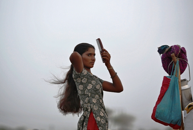 A village woman combs her hair after she migrated due to shortage of water on the outskirts of Sami town in Gujarat.