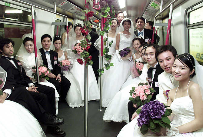 Couples pose for photographers in a subway train during a mass wedding in Hong Kong.
