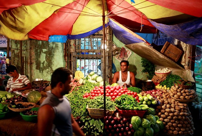 A vendor selling vegetables waits for customers at his stall at a market in Mumbai.