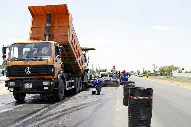 Labourers carry out surfacing work on a road near the Zambian capital Lusaka.