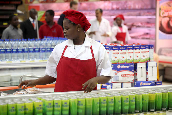 A shop assistant arranges products at the South African firm Shoprite's main store in Nigeria's commercial capital Lagos.