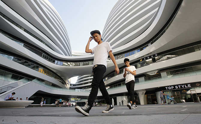 Two men walk on a square inside a commercial complex in Beijing, China.