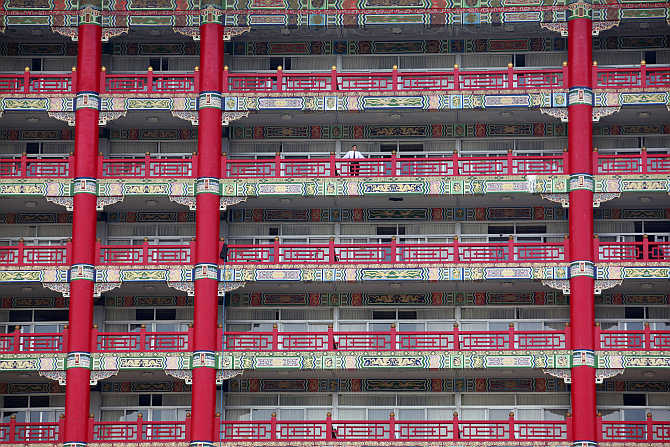A man stands on a balcony of a building in Taipei, Taiwan.