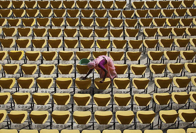 A worker cleans the seats of a stadium in Nagpur.
