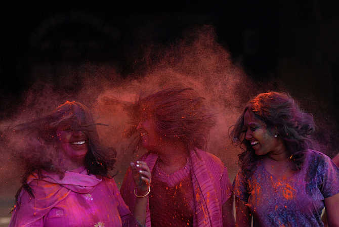 Girls react after coloured powder is thrown on them during Holi celebrations in Chennai.