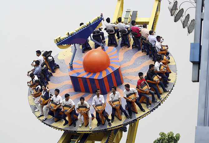 Visitors ride the Mega Disco roller coaster at an amusement park in Noida.