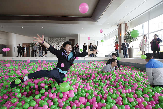 A man jumps in a swimming pool filled with pink and green plastic balls during a Guinness World Records attempt of the Largest Ball Pit in Pudong, Shanghai.