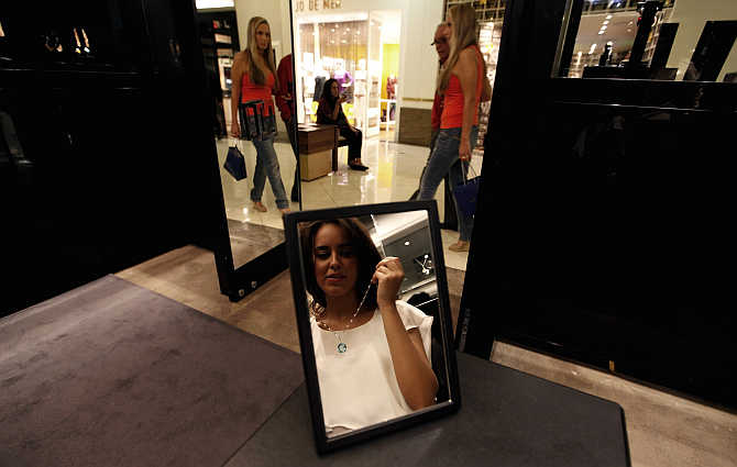 A woman tries on a necklace inside a jewellery store at the Iguatemi mall in Sao Paulo.