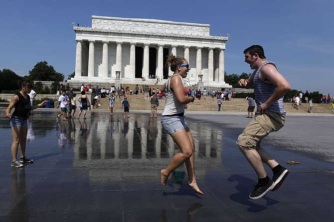 Karli Baumert and Max Cowdery dance underneath water sprinklers at the Lincoln Memorial in Washington, DC.