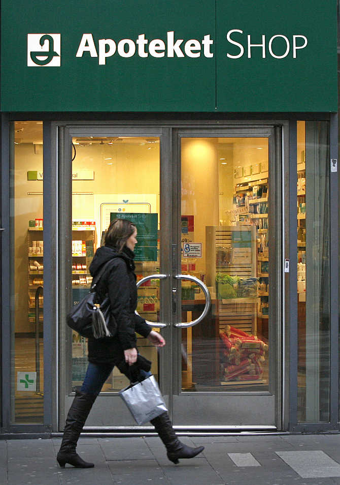 A pedestrian walks past a branch of Sweden's government-owned Apoteket pharmacy chain in downtown Stockholm.