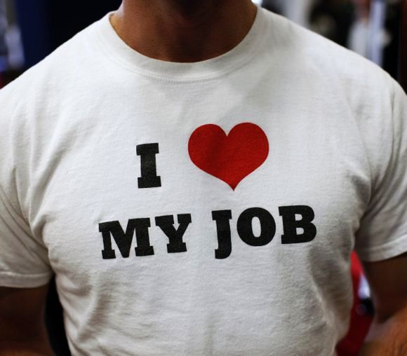  A recruiter for software a company wears a t-shirt as he meets job seekers at a career fair.