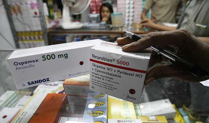 A pharmacy owner checks drugs at a market in Jakarta.