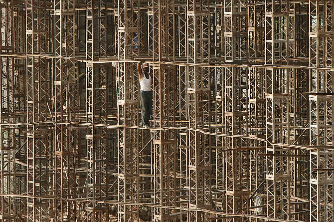 A construction worker stands on scaffolding on the outskirts of Jammu.