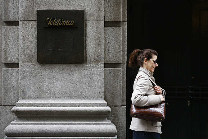 A woman walks past Telefonica's building in central Madrid, Spain.