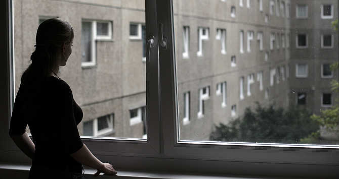 An employee looks out from a window at a hotel in Berlin.