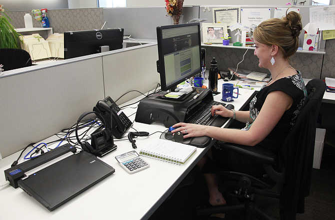 Danelle Hutton works on her laptop computer in her open cubicle at the US National Renewable Energy Laboratory Research Support Facility in Golden, Colorado.
